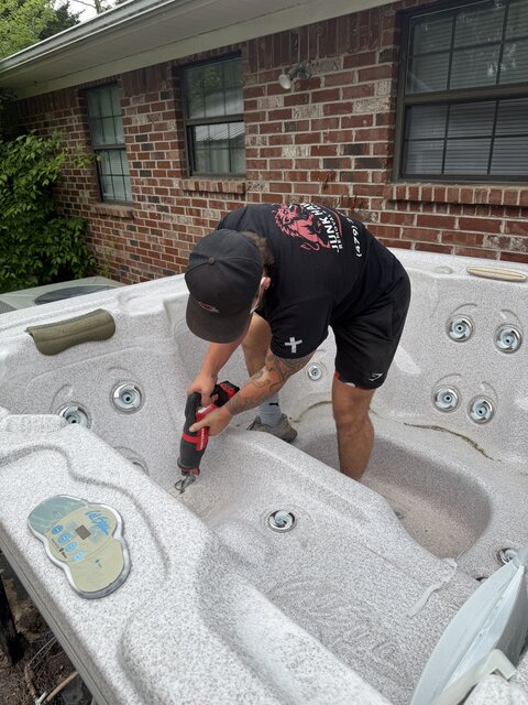 Crew cutting apart a hot tub shell for removal