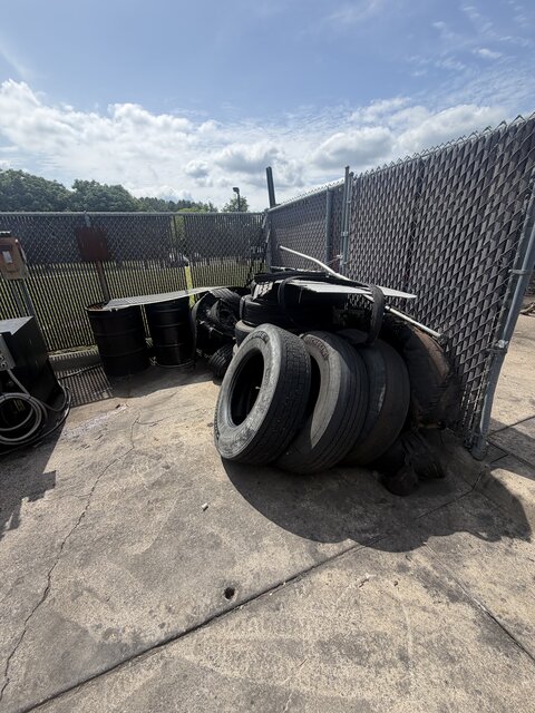 Tires and scrap metal staged for removal at a commercial yard