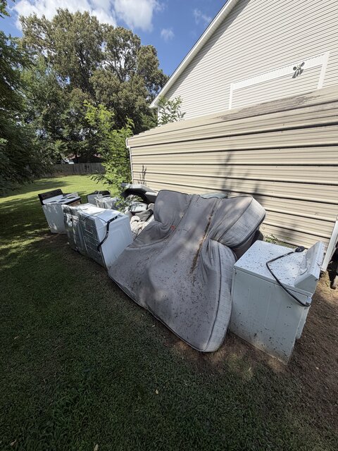 Appliances and furniture staged for pickup at a commercial property